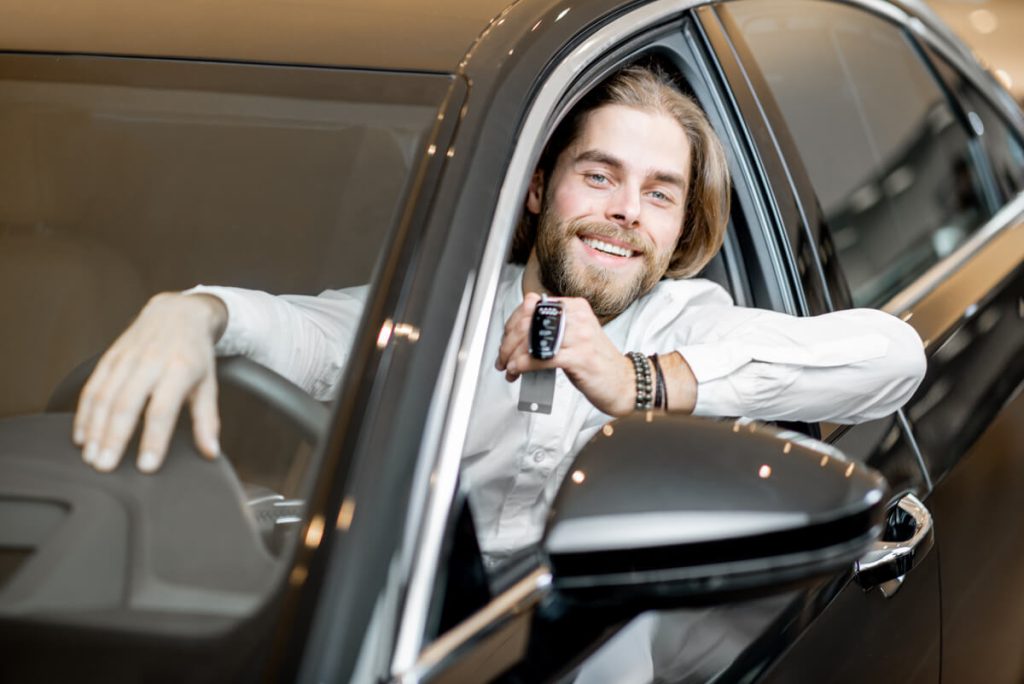 happy man in a new car at the showroom 2023 11 27 05 23 23 utc