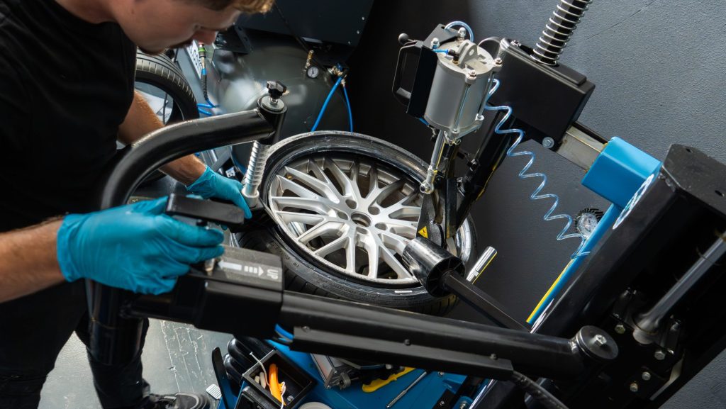 Monteur monteert autoband op velg met professionele apparatuur