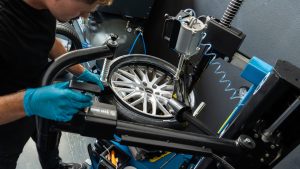 Monteur monteert autoband op velg met professionele apparatuur