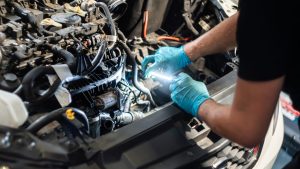 Monteur voert onderhoudsbeurt uit aan auto in werkplaats